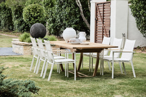 teak outdoor extension table with white arm chairs