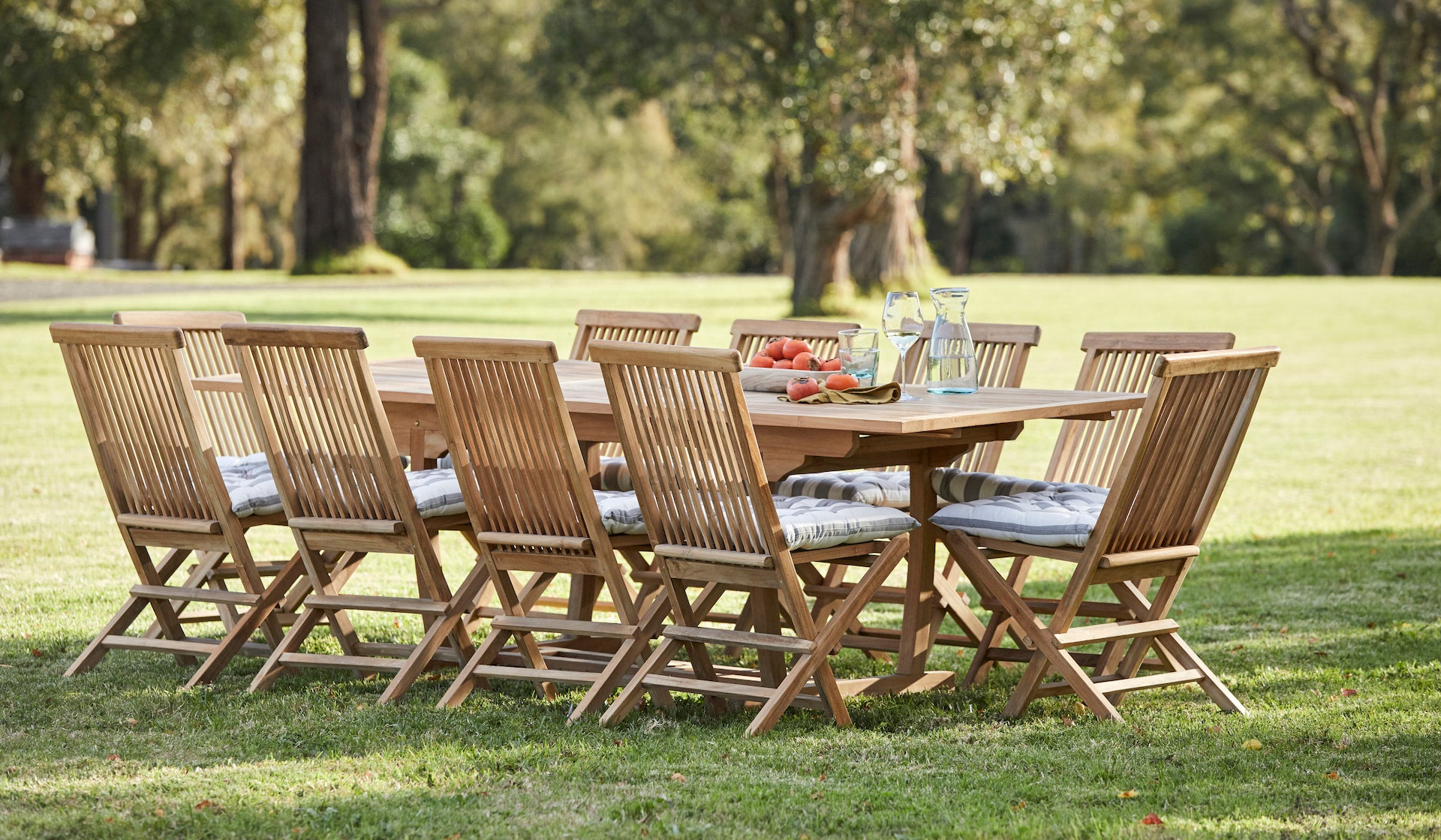 Wooden outdoor dining set with table and chairs on a grassy lawn