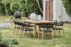teak outdoor extension table with black rope arm chairs
