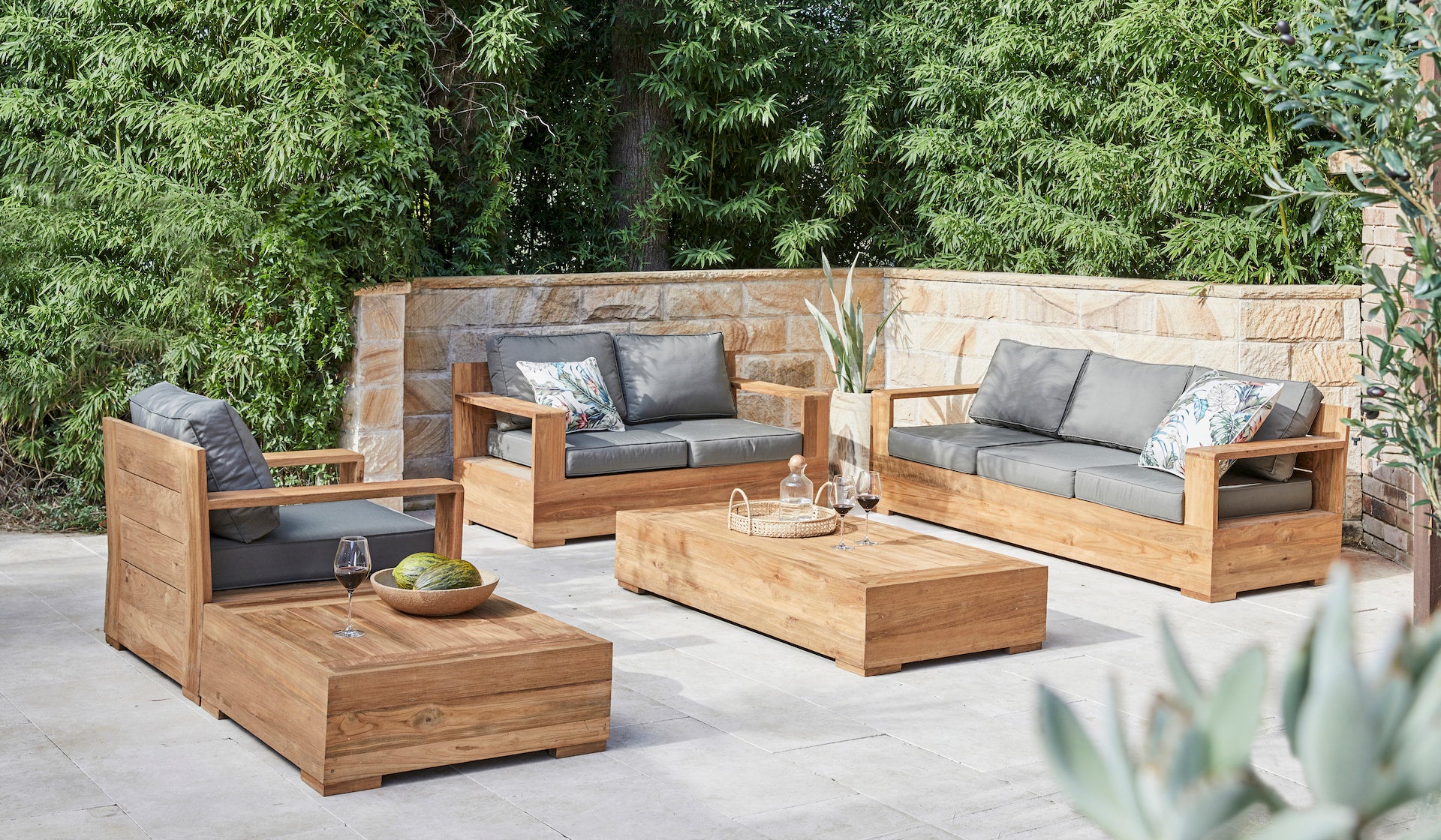 Outdoor patio furniture set with wooden chairs and sofa against a natural background